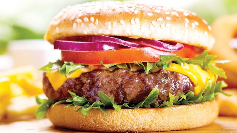 hamburger with fries on wooden table